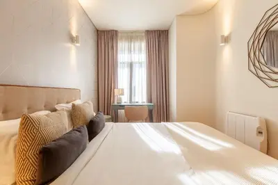 a bedroom with a large white bed and a desk at D&S - Alvares Cabral in Porto