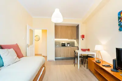 a living room with a white couch and a kitchen at GuestReady - A pleasant stay in Porto in Porto