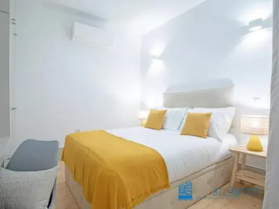 a bedroom with a bed with yellow sheets and a chair at Porto Almada Design Loft in Porto
