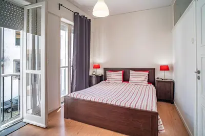 a bedroom with a bed and a large window at OPO Domus in Porto