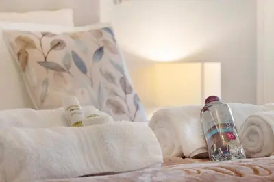 a bottle of water and towels on a bed at Apartment Boutique Santa Catarina 2 in Porto