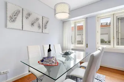 a dining room with a glass table and white chairs at Apartment Boutique Santa Catarina 2 in Porto