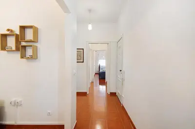 a hallway with white walls and a tile floor at Trindade Porto City Centre in Porto