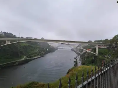a bridge over a river with a bridge in the background at DOUROVIEW in Porto