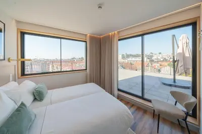 a bedroom with a large bed and a large window at Feel Porto Firmeza Coworking & Flats in Porto