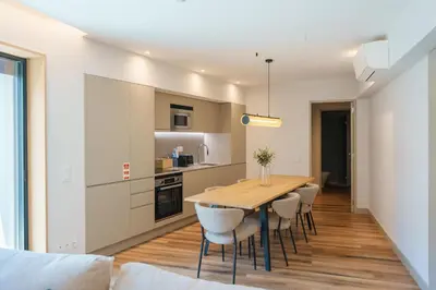 a kitchen and dining room with a wooden table and chairs at Feel Porto Firmeza Coworking & Flats in Porto
