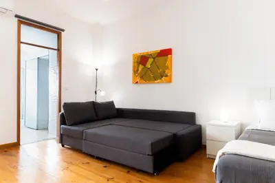 a living room with a couch and a painting on the wall at PORTO GARDEN YARD APARTMENT in Porto