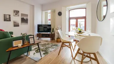 a living room with a table and a green couch at Old Town 1BR Duplex by LovelyStay in Porto