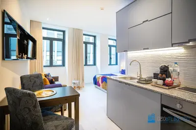 a kitchen with a sink and a living room at Porto Formosa Central Lofts in Porto