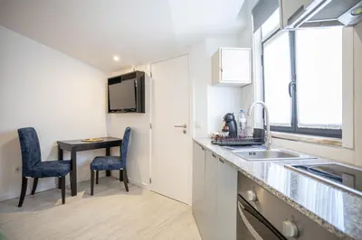 a kitchen with a sink and a table with chairs at Porto Formosa Central Lofts in Porto