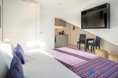 a bedroom with a bed and a flat screen tv at Porto Formosa Central Lofts in Porto