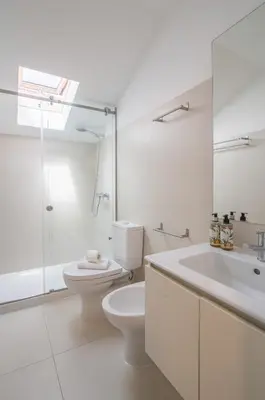 a white bathroom with a toilet and a sink at Almada 151 Porto in Porto