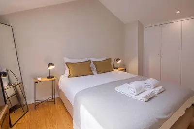 a bedroom with a white bed with towels on it at Almada 151 Porto in Porto