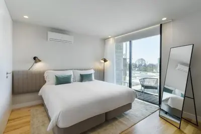 a bedroom with a large bed and a large window at Feel Porto Corporate Housing Boavista in Porto