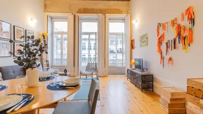 a dining room with a table and a television at Eccentric Mouzinho Mezzanine by LovelyStay in Porto