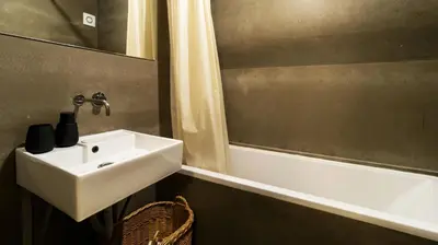 a bathroom with a sink and a mirror and a tub at Eccentric Mouzinho Mezzanine by LovelyStay in Porto