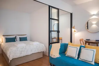 a bedroom with a bed and a blue couch at Santa Catarina Charm Apartment Downtown near Metro in Porto