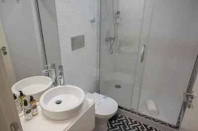 a bathroom with a shower and a sink and a toilet at Glamour by the River in Porto