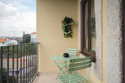 a green table and two chairs on a balcony at Glamour by the River in Porto