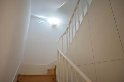 a white staircase with a light on the wall at Glamour by the River in Porto