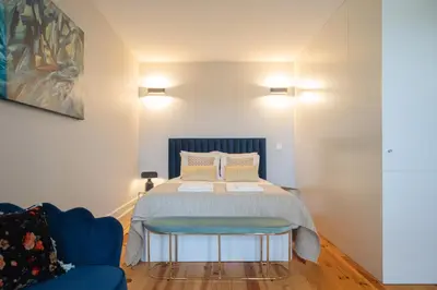 a bedroom with a bed and a blue couch at Glamour by the River in Porto