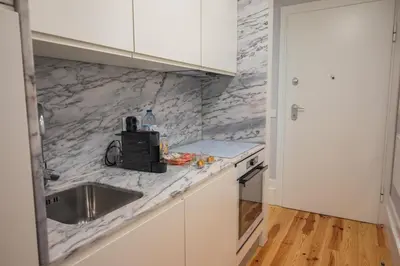 a kitchen with white marble counter tops and a sink at Glamour by the River in Porto