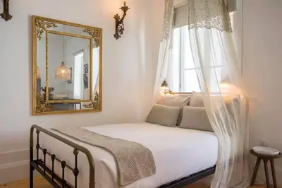 a bedroom with a bed with a mirror and a window at 157 Flores Apartment in Porto