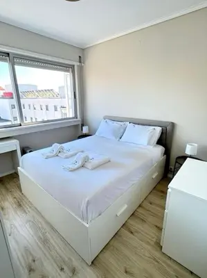 a white bed in a room with a window at The Cale - Porto, Sá da Bandeira in Porto