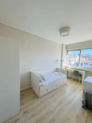 a white room with a bed and a desk and a window at The Cale - Porto, Sá da Bandeira in Porto