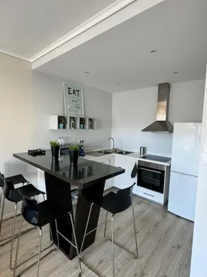 a kitchen with a black table and black chairs at The Cale - Porto, Sá da Bandeira in Porto