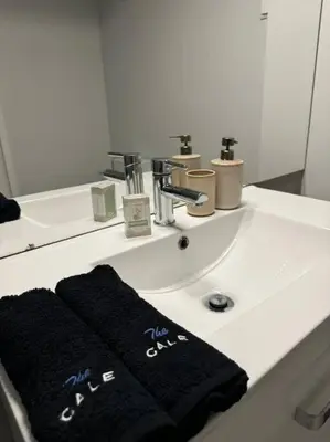 a bathroom sink with two black towels on it at The Cale - Porto, Sá da Bandeira in Porto