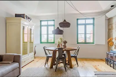 a living room with a table and chairs and a couch at 1892 - Ribeira Loft in Porto