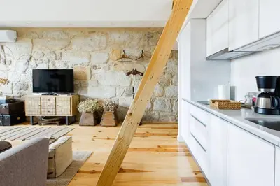 a kitchen and living room with a stone wall at 1892 - Ribeira Loft in Porto