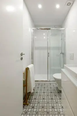 a white bathroom with a shower and a toilet at Oporto Cosy Apartment in Porto