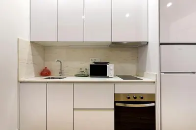 a kitchen with white cabinets and a microwave at Oporto Lovely Apartment in Porto