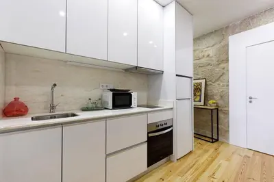 a kitchen with white cabinets and a microwave at Oporto Lovely Apartment in Porto