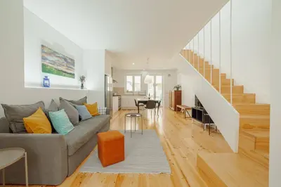a living room with a gray couch and a staircase at Modern Villa by Hosty in Porto