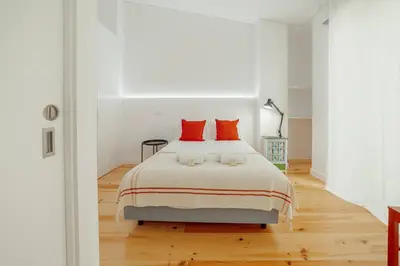 a white bedroom with a large bed with red pillows at Modern Villa by Hosty in Porto