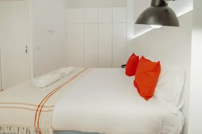 a white bed with two red pillows on it at Modern Villa by Hosty in Porto
