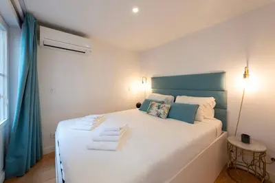 a bedroom with a large white bed with towels on it at Mouzinho Rooftop View in Porto