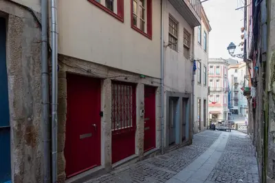 an empty alley with red doors on a building at Mouzinho Rooftop View in Porto