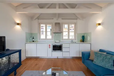 a kitchen with white cabinets and a blue couch at Mouzinho Rooftop View in Porto
