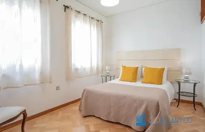 a white bedroom with a large bed with yellow pillows at Porto Sé Classic Terrace Apartment in Porto