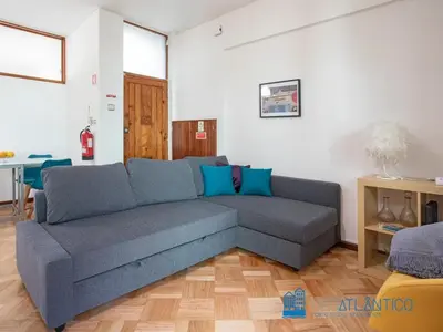 a living room with a blue couch in a room at Porto Sé Classic Terrace Apartment in Porto