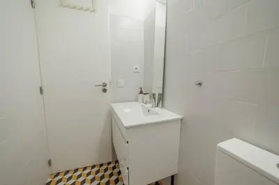 a white bathroom with a sink and a mirror at Cozy Almada by Hosty in Porto