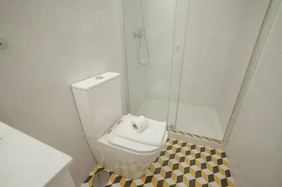 a bathroom with a white toilet and a shower at Cozy Almada by Hosty in Porto