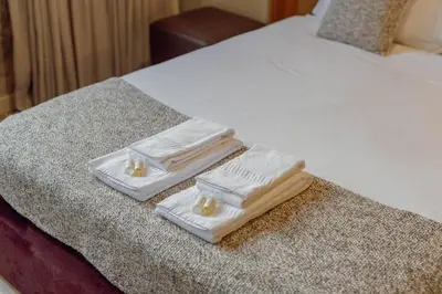 three towels are sitting on the edge of a bed at Flores Deluxe by Hosty in Porto