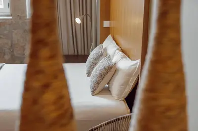 a bed with pillows on it in a room at Flores Deluxe by Hosty in Porto
