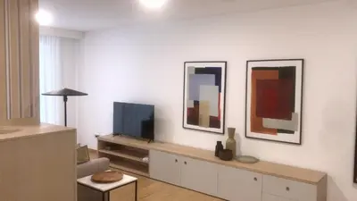 a living room with a tv and three paintings at Oporto Chic & Cozy - Anibal Cunha in Porto