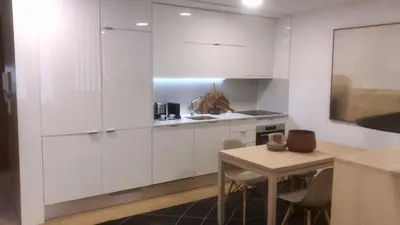 a kitchen with white cabinets and a table with chairs at Oporto Chic & Cozy - Anibal Cunha in Porto